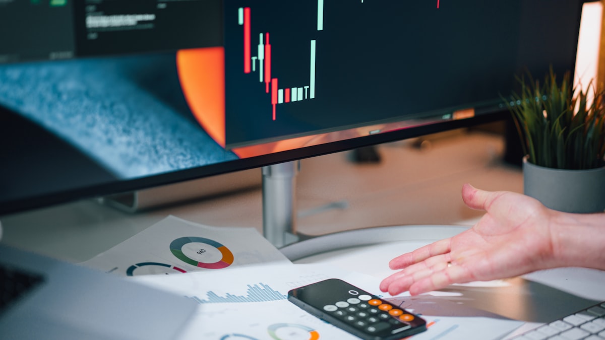3 Characteristics of Winning Traders – Traits you must develop — a person pointing at a calculator on a desk