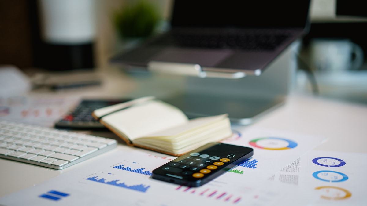 Calculating Position Size — office desk with smartphone and financial charts