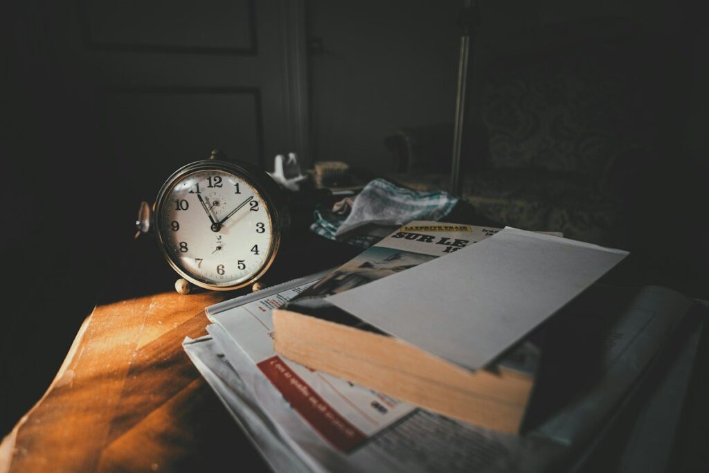Alarm clock beside papers on a desk, a reminder that US data times move when the clocks change