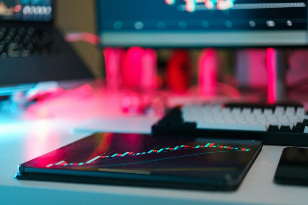 Tablet with a chart on a desk in front of glowing screens