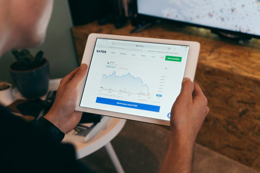 Hands holding a tablet showing a line chart