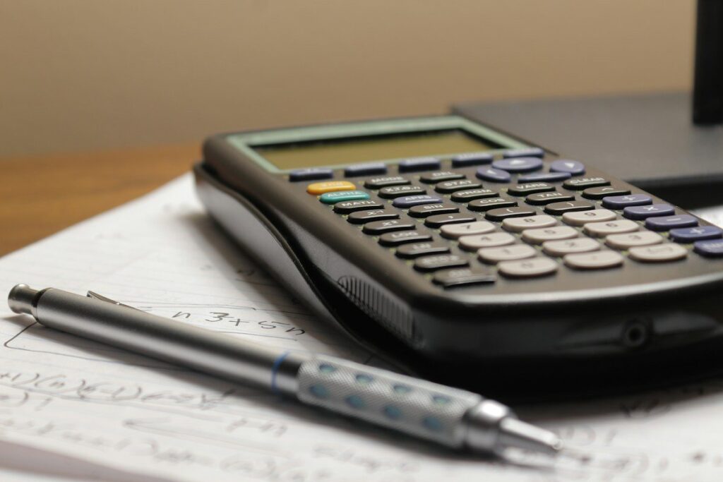 Calculator and notepad used to work out a smaller position size after losses to curb emotional trading