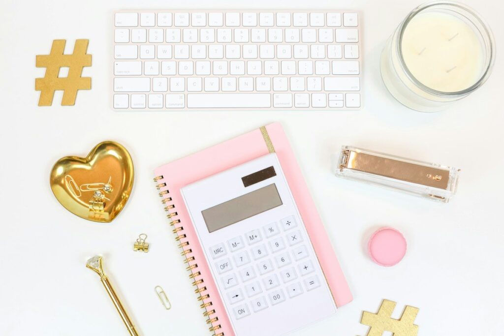 Calculator, notepad and keyboard on a white desk