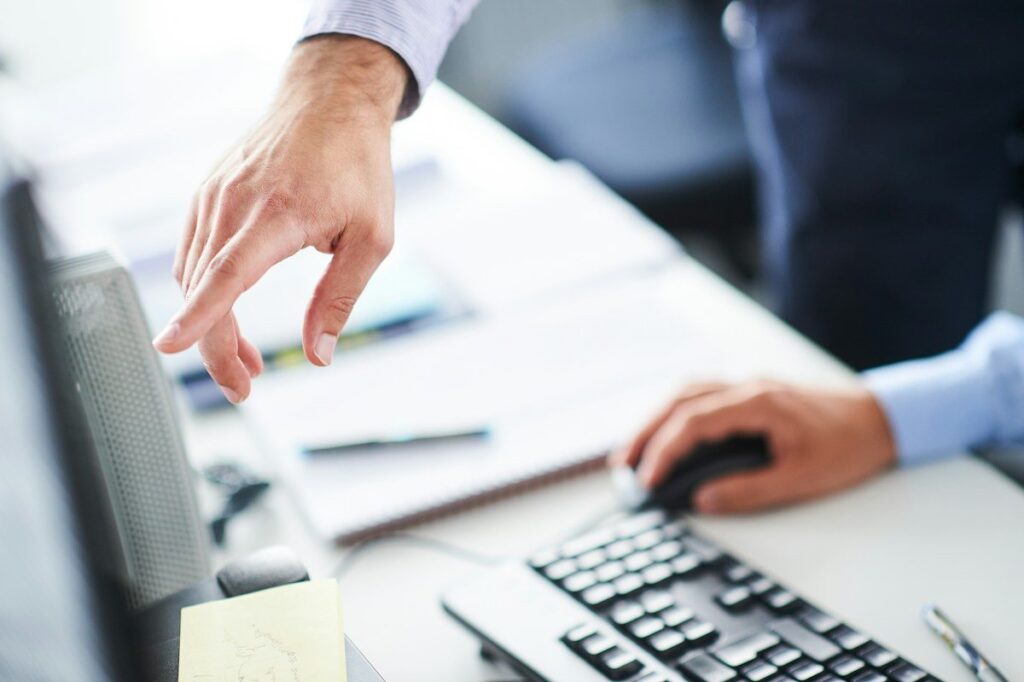 Hand pointing at a monitor while working out the risk and reward of a graded price action setup