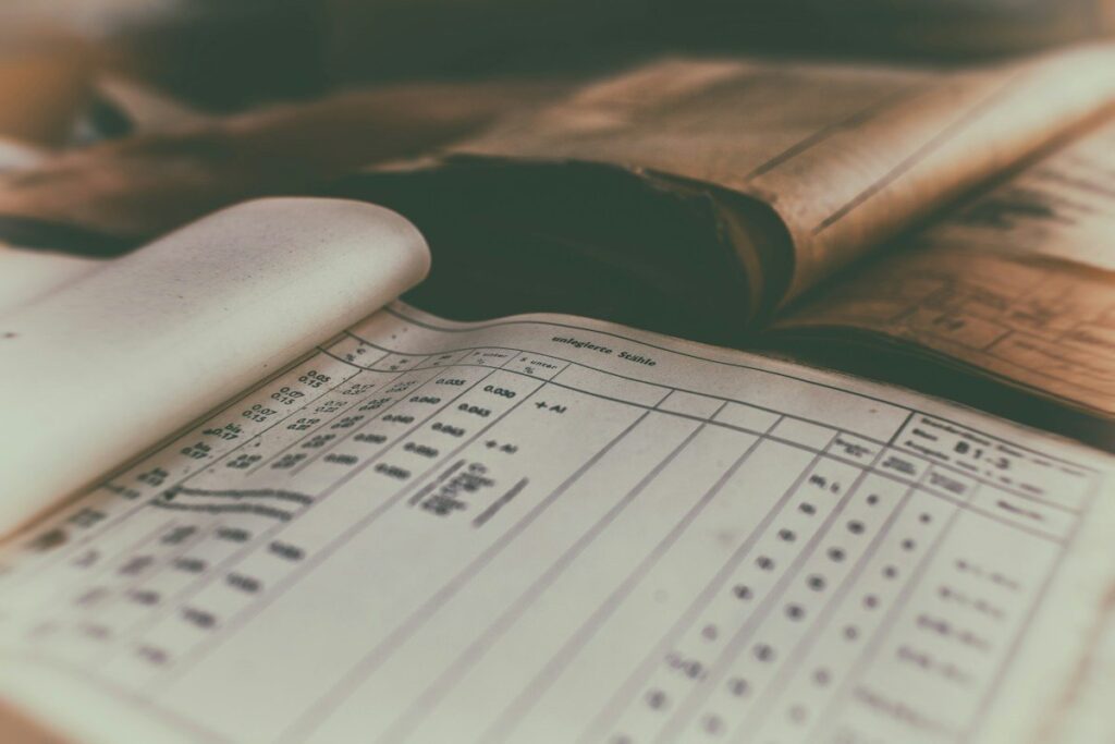 Old ledger with handwritten columns of figures, the kind of sums used to size a position from the entry timeframe's stop