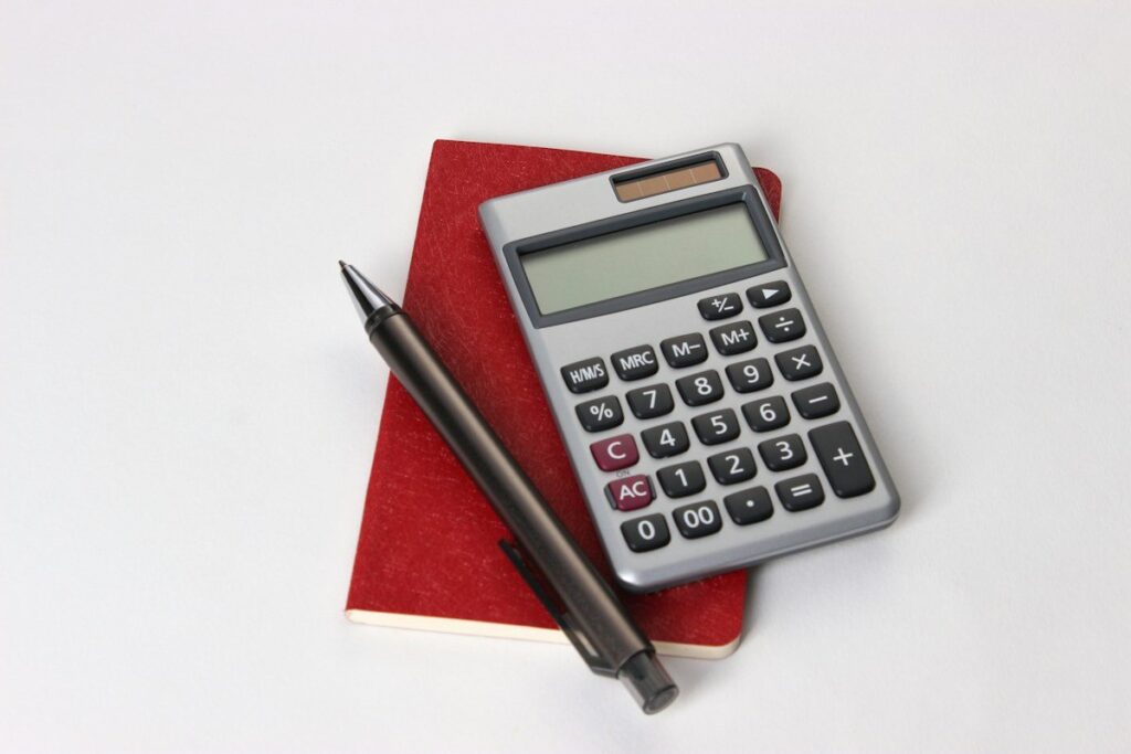 Calculator and notepad used to size a worked example after reading price action