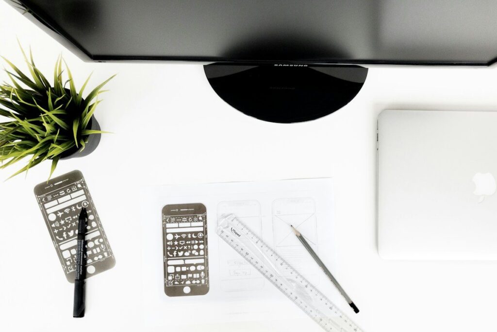 Smartphone, ruler and pencil on a white desk, used to size a double top trade from its stop distance
