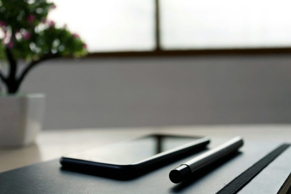 Tablet and pen on a dark desk, ready to convert pip value from dollars into pounds
