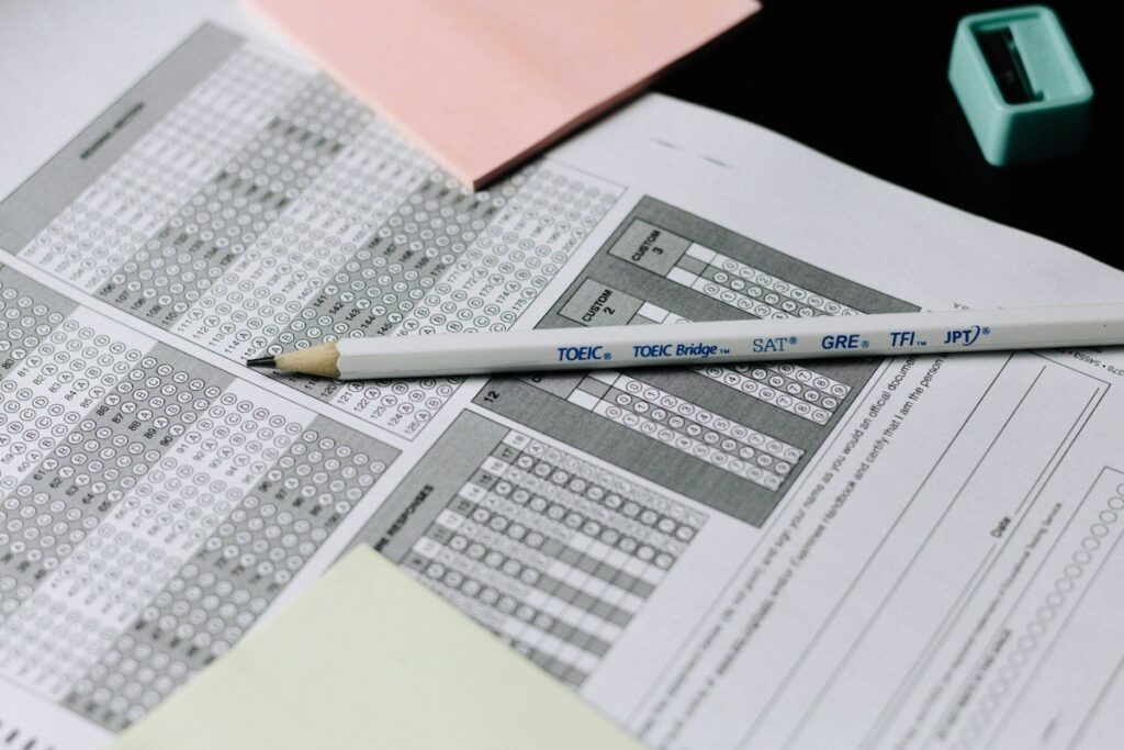 Pencil resting on printed sheets of figures, adding up the spread cost of extra trades