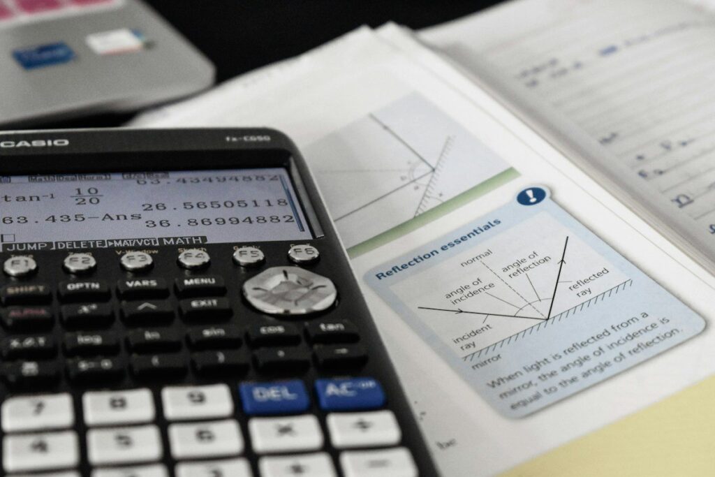 Hand using a calculator to check how a late entry changes reward to risk when chasing a move