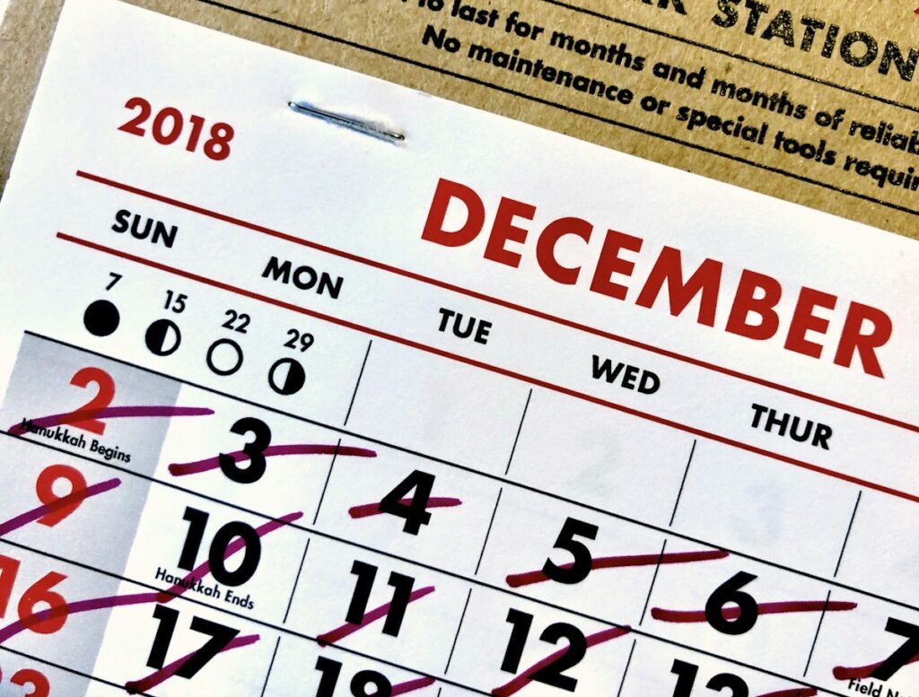 Paper calendar with dates crossed out in red, marking the clock-change weeks that shift gold trading times