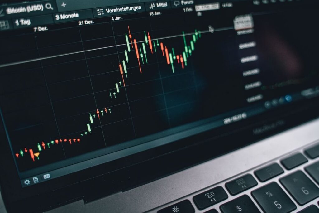 Laptop screen showing a candlestick chart