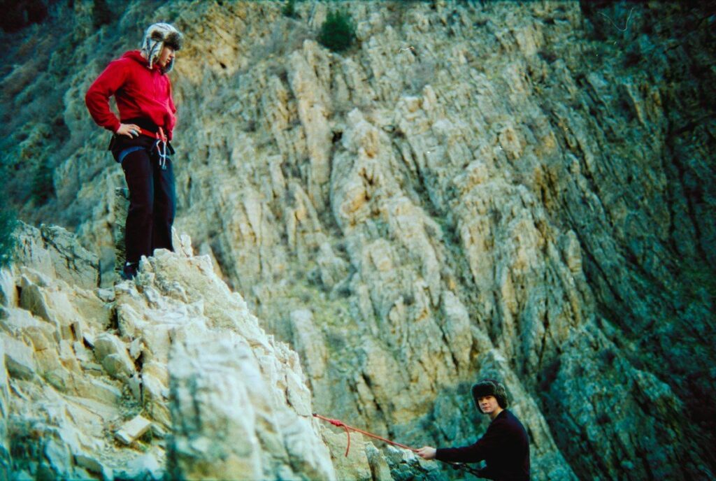 Two climbers on a rock face with a safety rope, like setting a stop beyond the level that proves a trade wrong