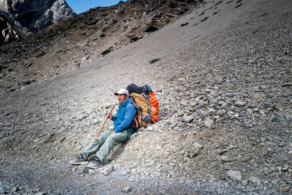 Climber resting below a summit, like the right shoulder failing to reach the head's high