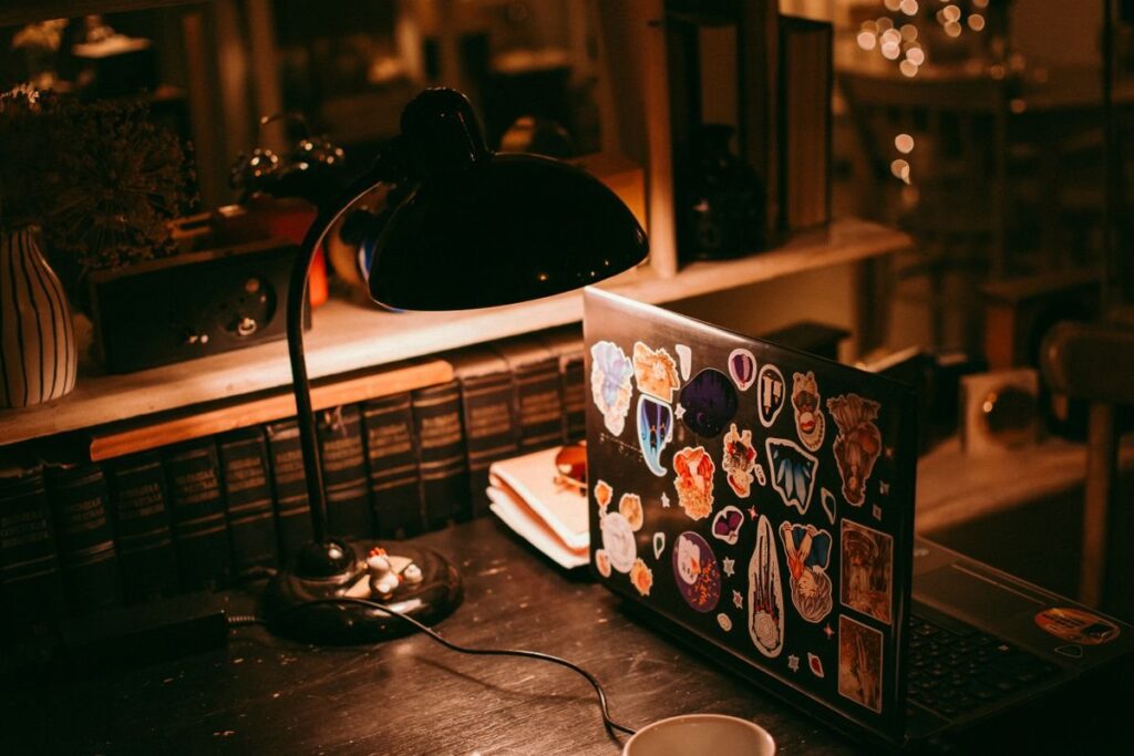 Laptop under a desk lamp at night