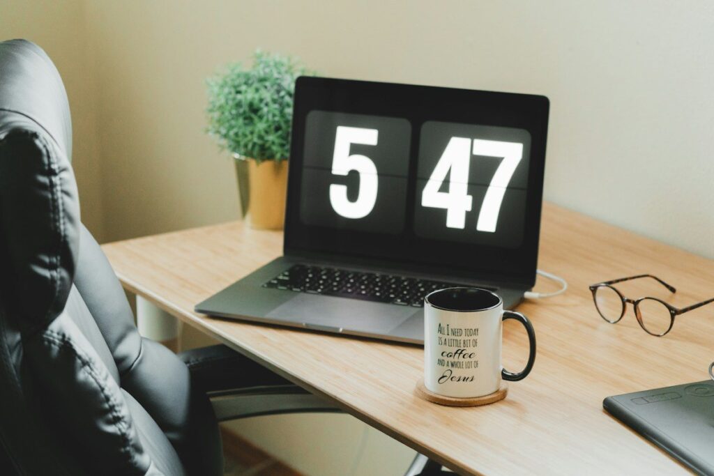 Clock above a laptop while a trader waits for a candle close to confirm a break of structure