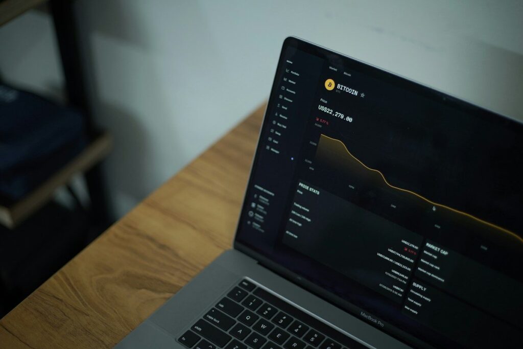 Laptop showing a price chart on a wooden table