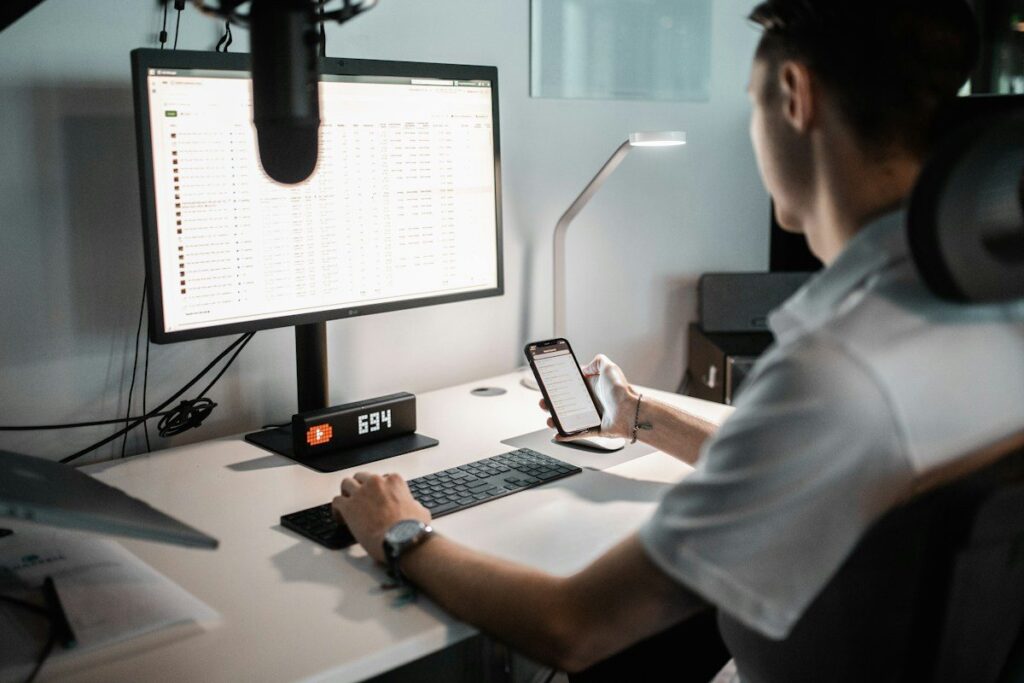 Person at a desk with a monitor and a phone