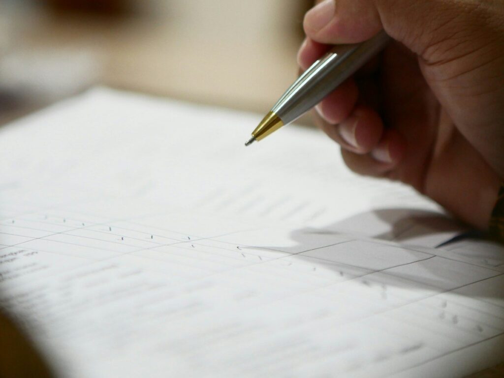 Hand correcting figures on a printed report, like a revision to last month's economic data