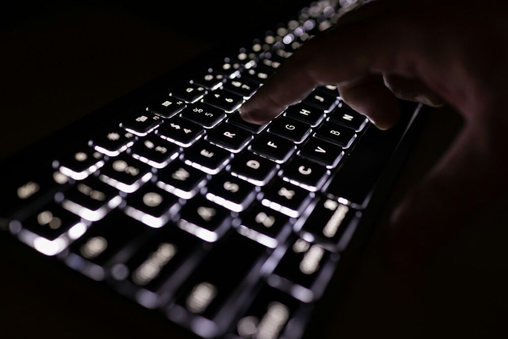 Hand pausing over a keyboard while waiting for a price action confirmation entry