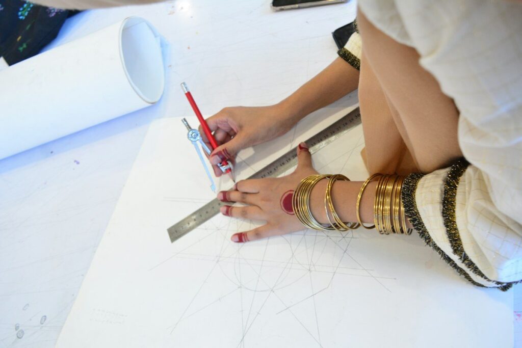 Hand drawing a line with a ruler and pencil, as when connecting two swing lows to draw a trendline