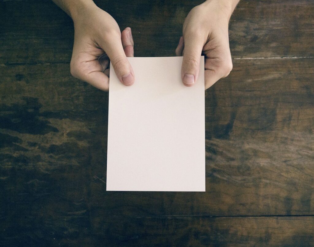 Hands holding a blank index card, like ranking key levels and keeping only the strongest few