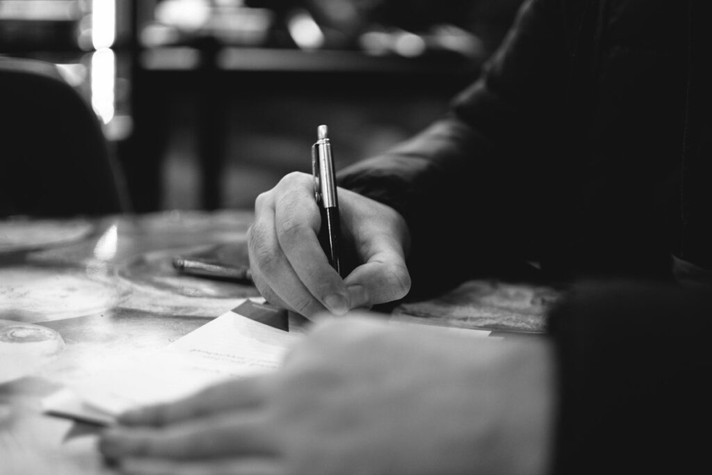 Hand writing an engulfing candle trade plan with entry, stop and target on an index card