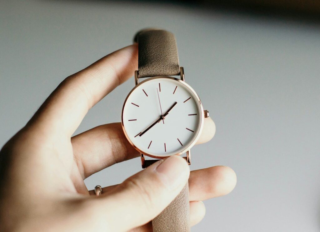 Hands adjusting a wristwatch, a reminder that forex data times shift in UK time when clocks change