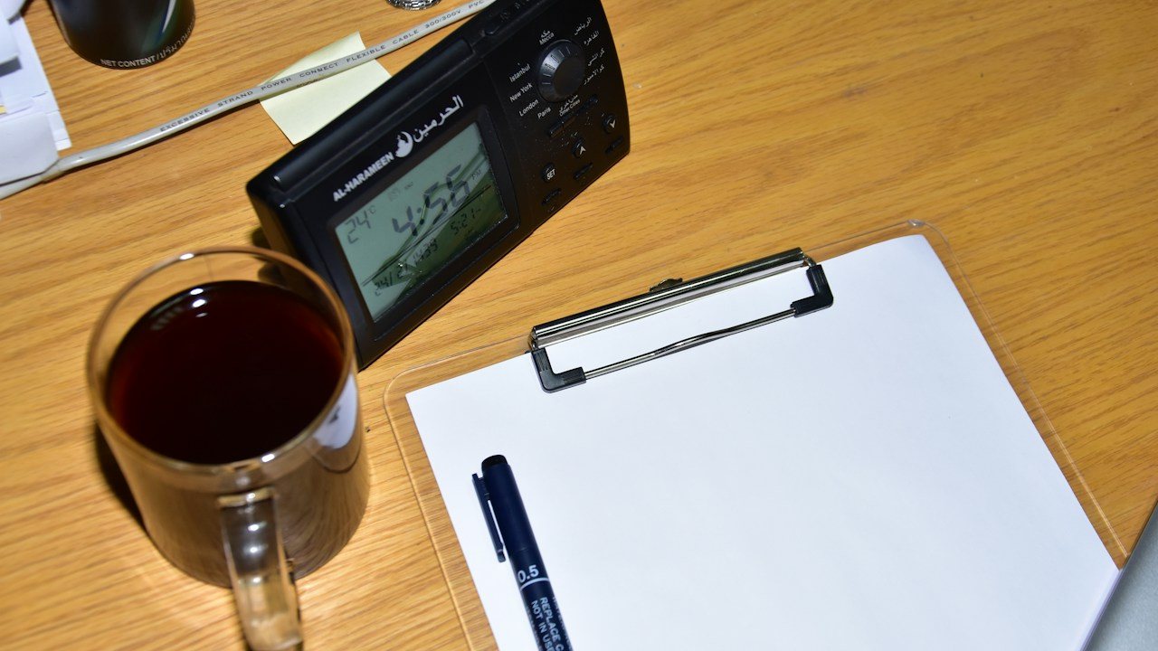 Clipboard with blank paper and a pen on a desk, ready for a checklist to grade price action setups
