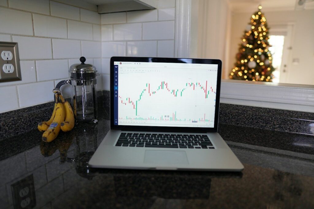 Laptop showing a candlestick chart on a kitchen worktop