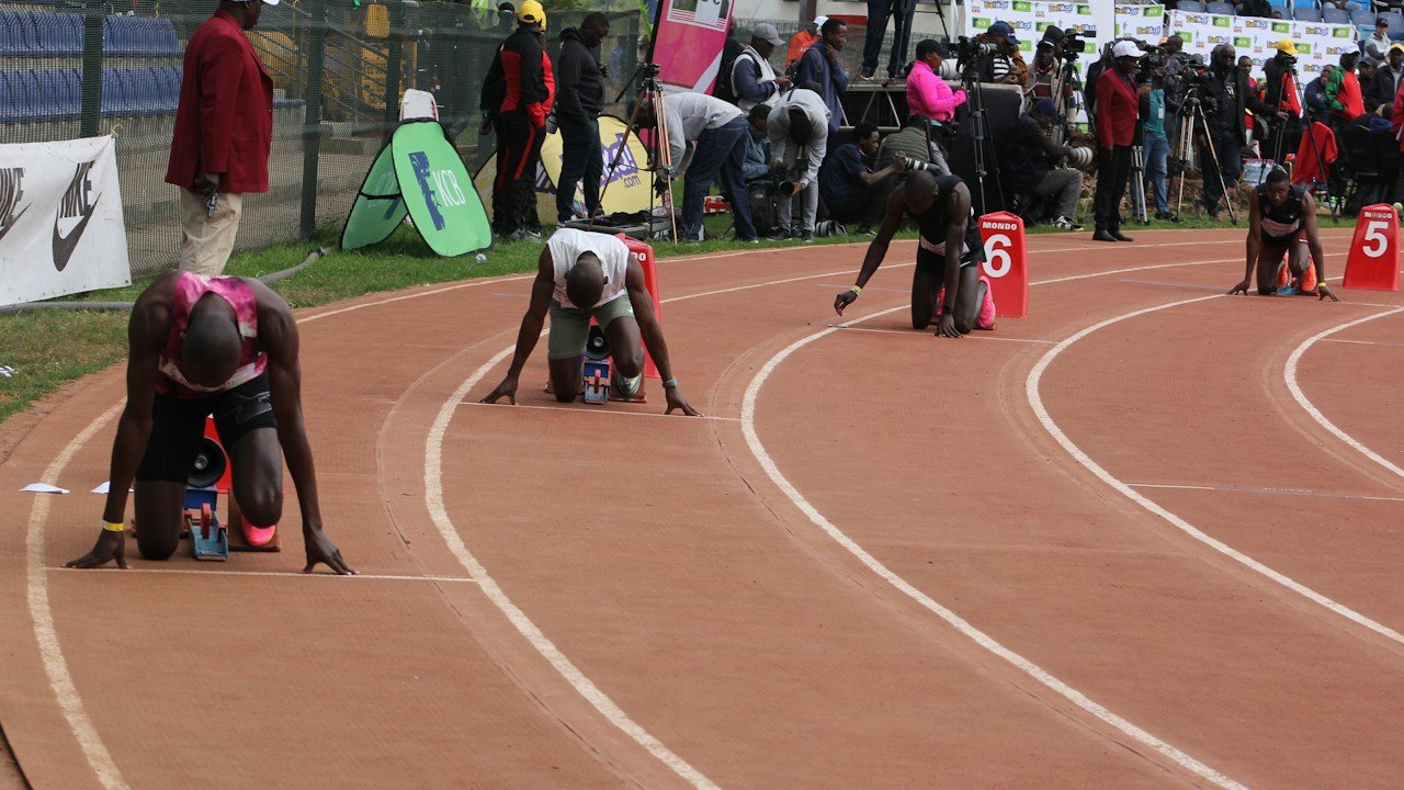 Sprinter crouched in starting blocks, like price coiled inside a mother bar before an inside bar breakout