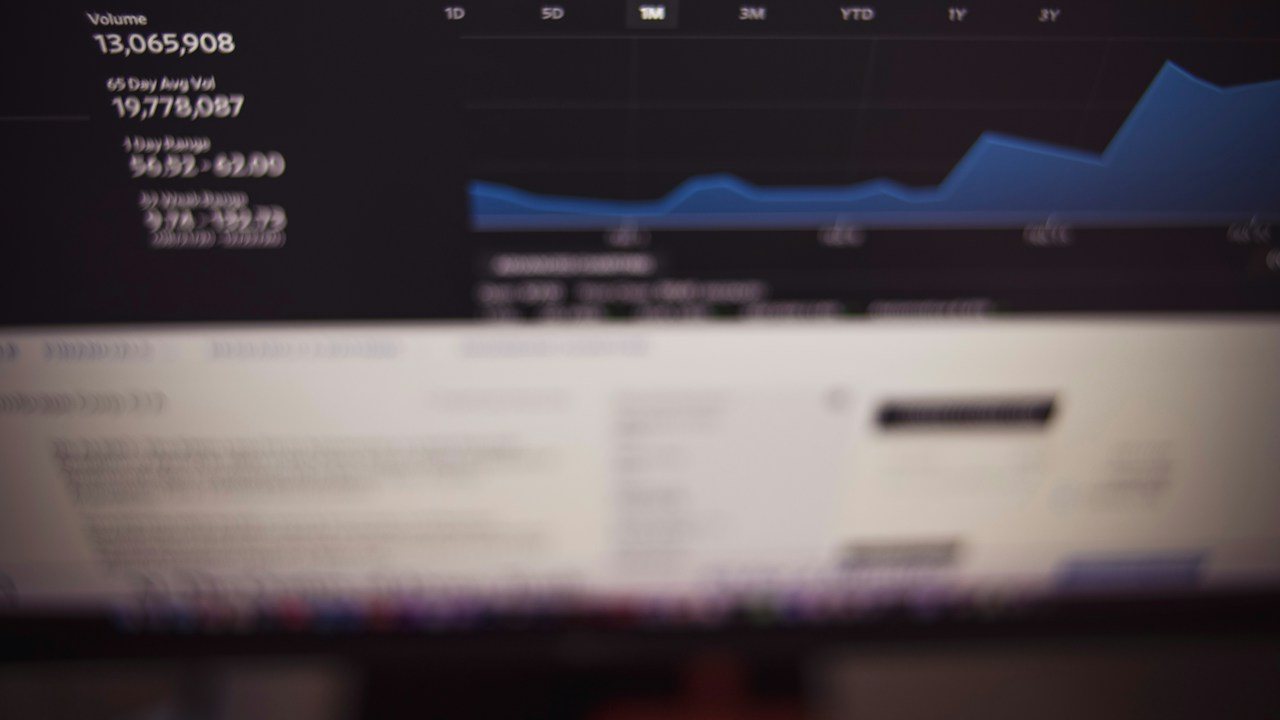 Blurred screen showing a price chart and volume figures