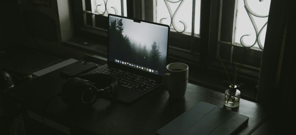 Laptop and coffee on a desk by a window, set up to plan a trade targeting a naked point of control