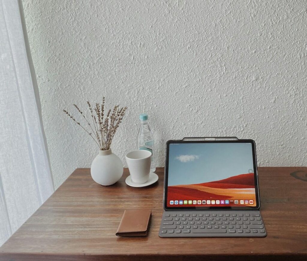 Tablet and keyboard on a wooden table, ready for logging backtest results for a new trading system