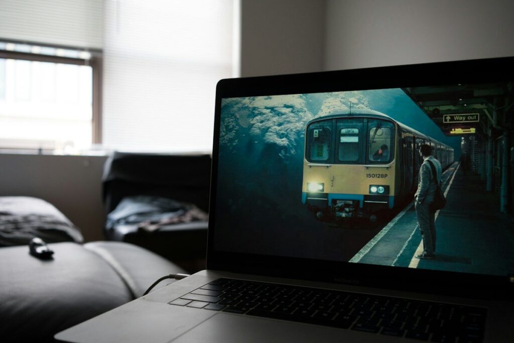 Laptop open on a sofa at home, used to check the hourly US500 chart for the current swing