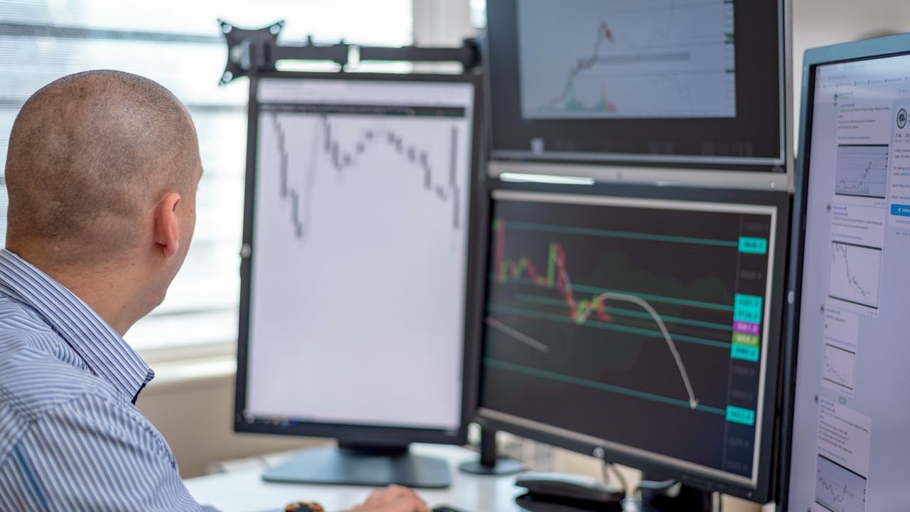 Trader watching multiple trading screens