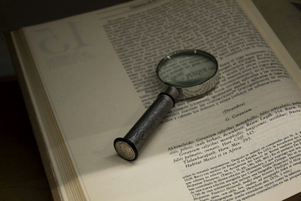 Magnifying glass over a printed page of figures, checking backtest results for overfitting and hidden bias