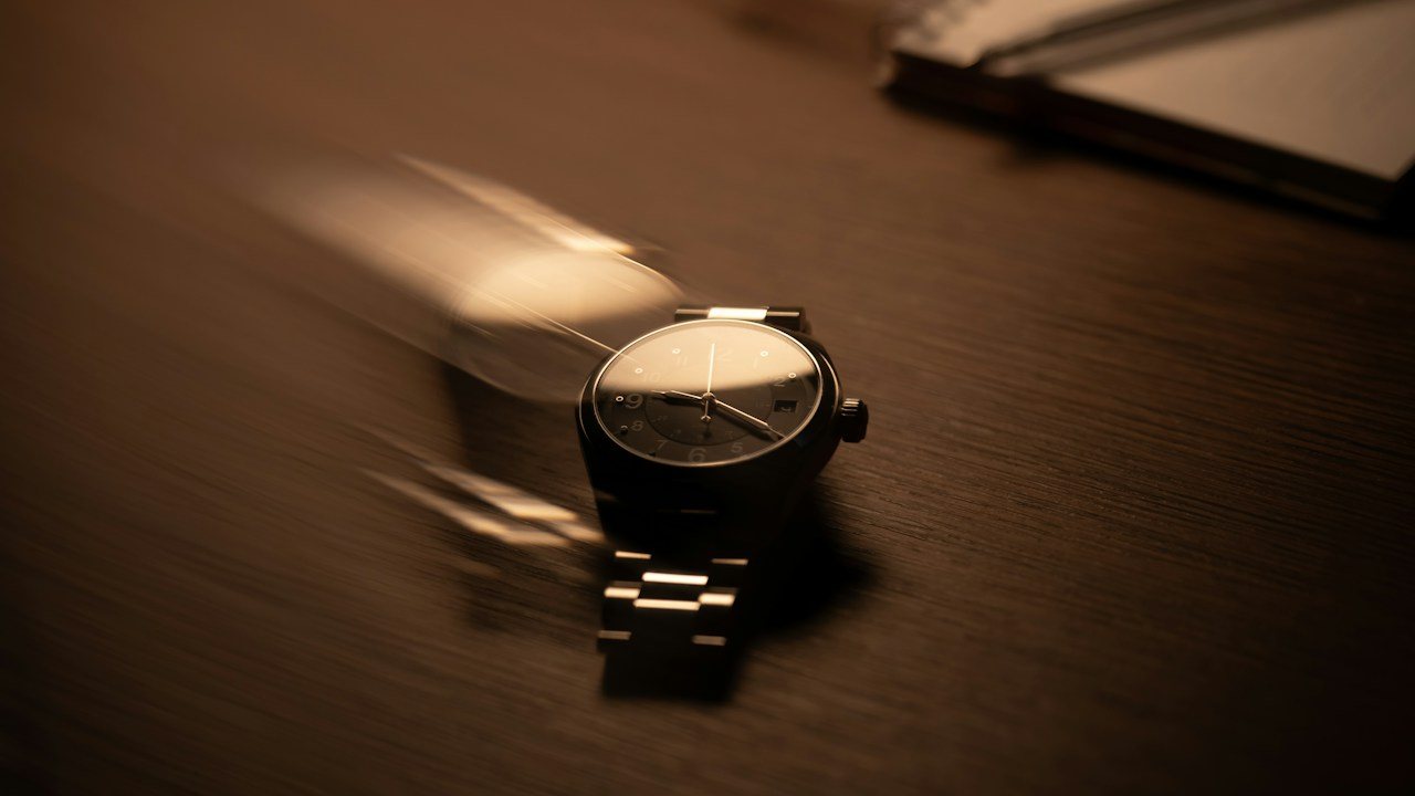 Wristwatch on a dark desk, a reminder that Market Profile measures time while volume profile measures volume