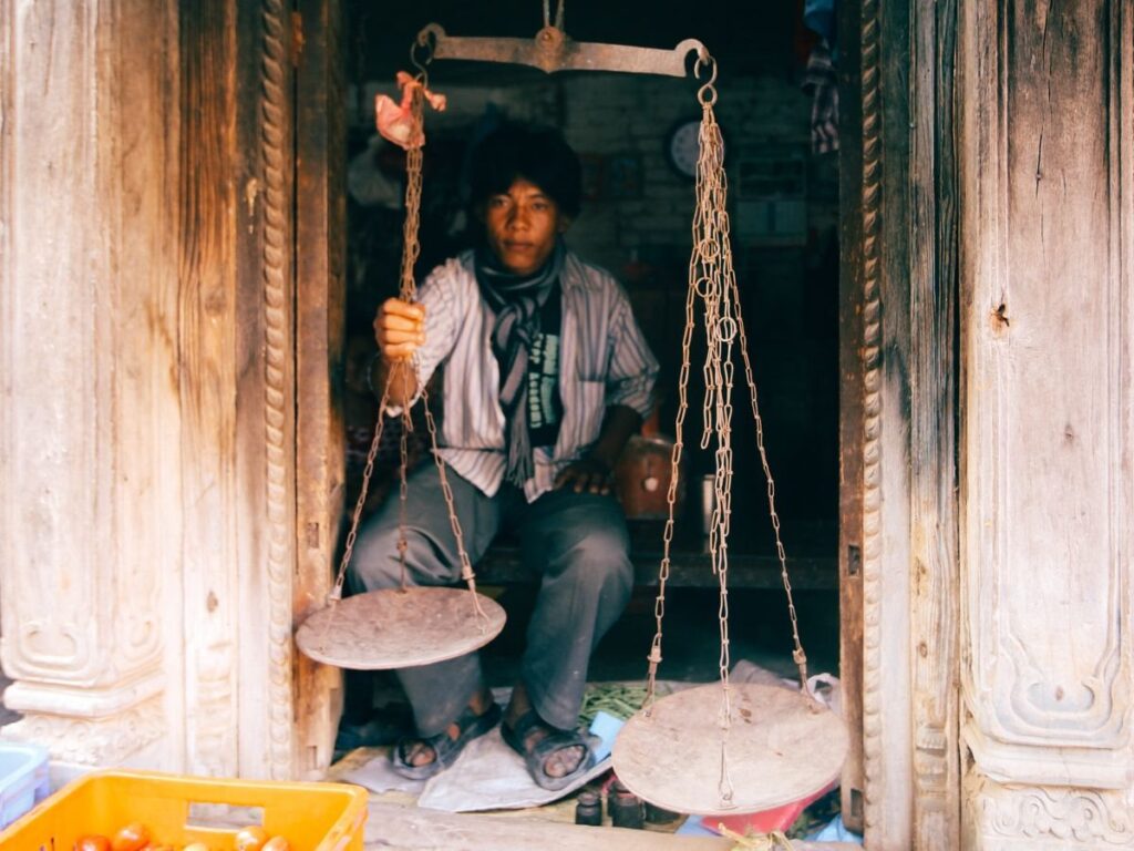 Brass weighing scales on a market stall, a reminder that the POC marks where buyers and sellers agreed fair value