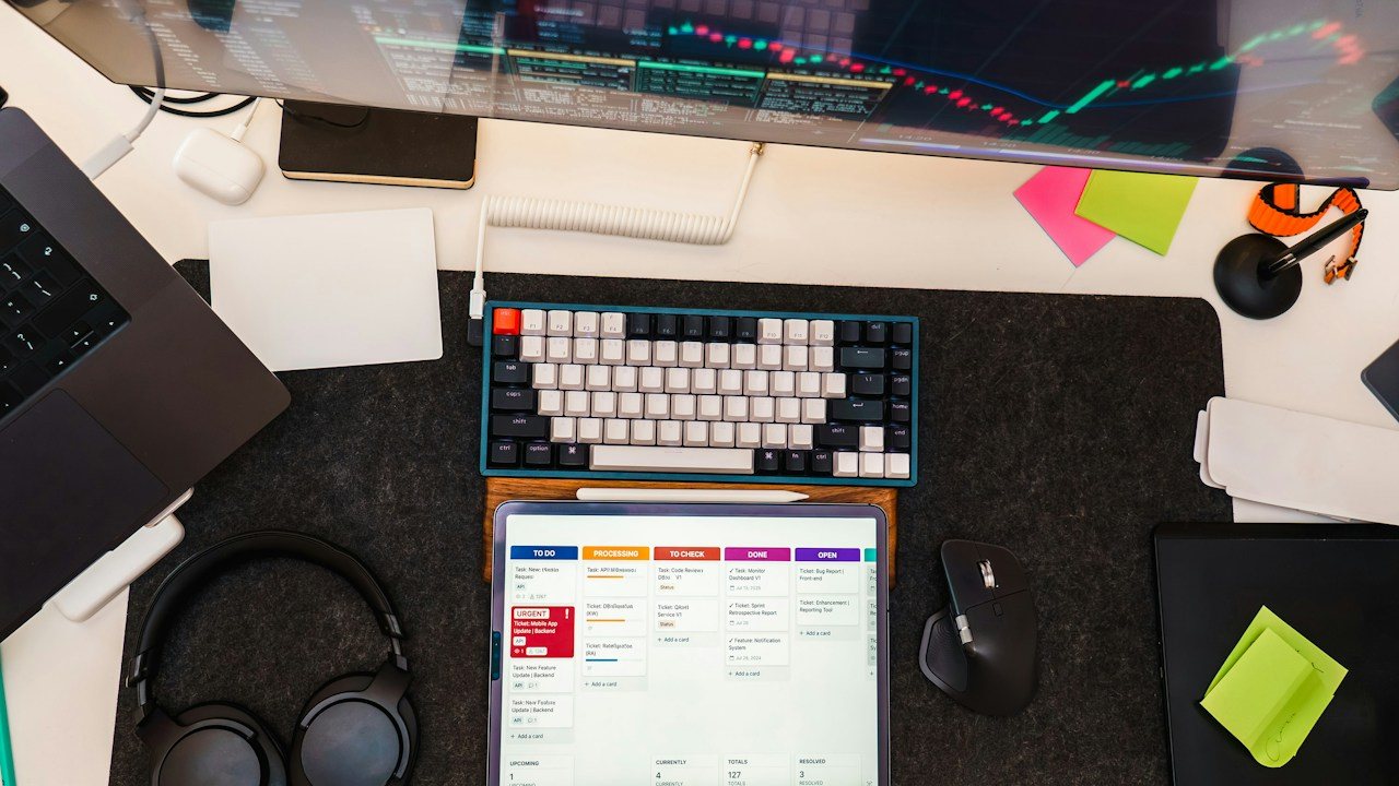Desk seen from above with a keyboard, tablet and monitor