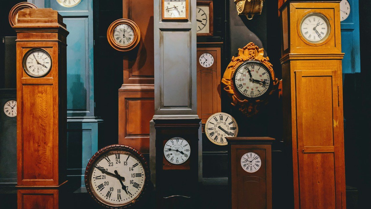 Collection of antique clocks showing different times, like one market read on several timeframes