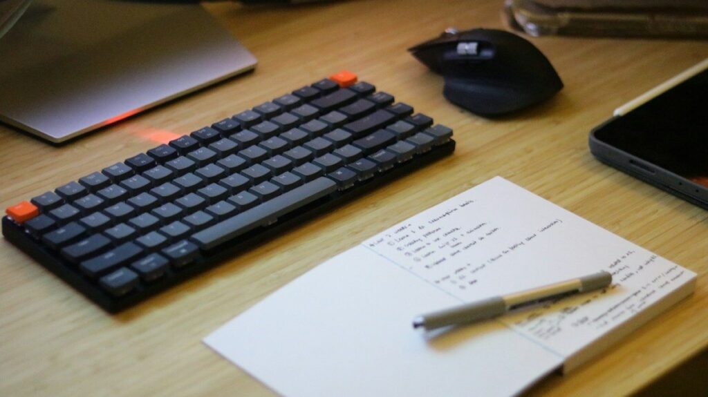 Notebook with handwritten notes beside a keyboard