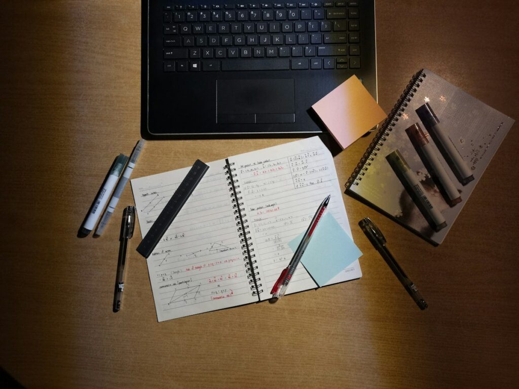 Notes on a notepad beside a laptop, setting out a price action routine for trading indices