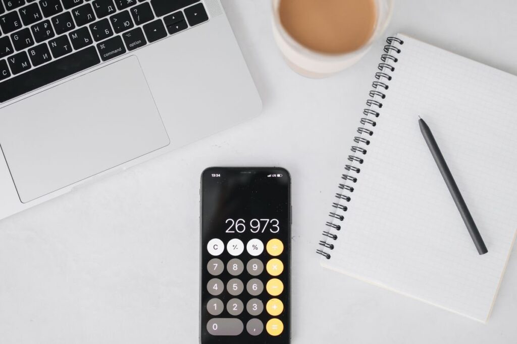 Phone calculator beside a notebook and a laptop