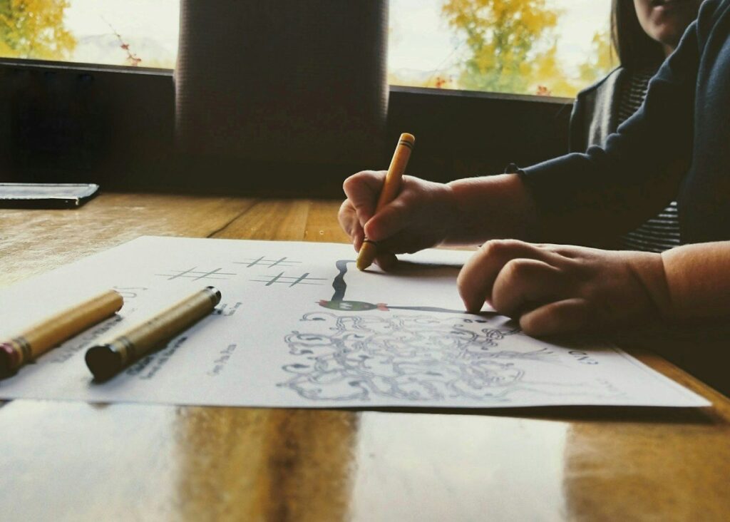 Hands filling in a ruled table on paper, copying the trading plan template by hand