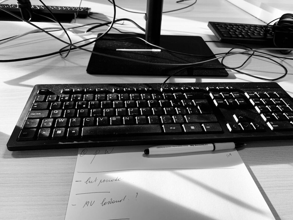 Handwritten notes on paper beside a keyboard