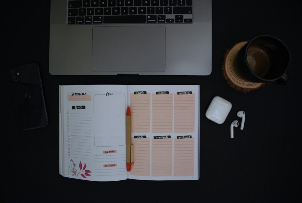 Open weekly planner beside a laptop, ready for the five criteria used to judge a forex pair for beginners