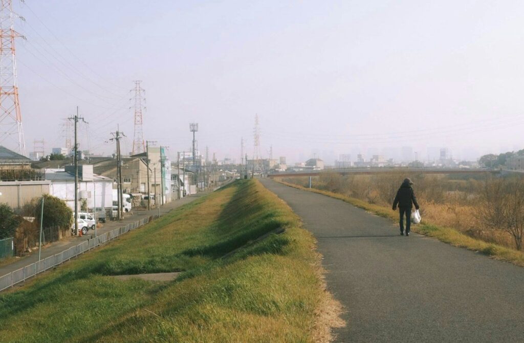 Person walking along a riverside path, taking a planned break after a trading loss