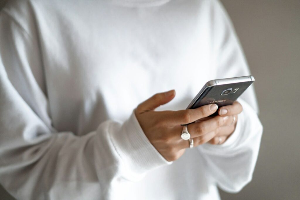 Trader checking a phone alert set at the retest level instead of watching the screen all day