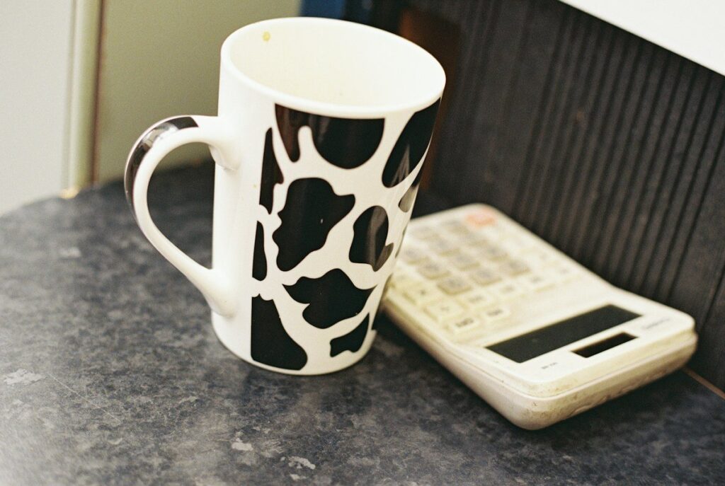 Pocket calculator beside a coffee mug on a desk, used to check the margin a spread bet needs